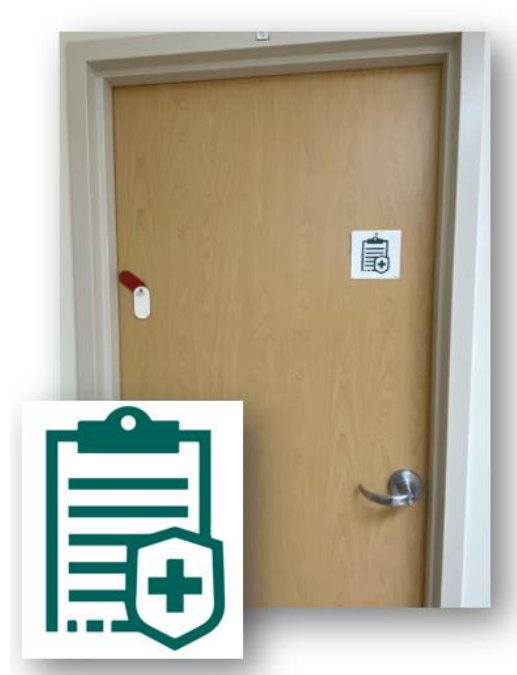 Image of a beige patient door with a rectangular decal on it. The decal is white with the image of a green clipboard and a small shield with a cross on it.