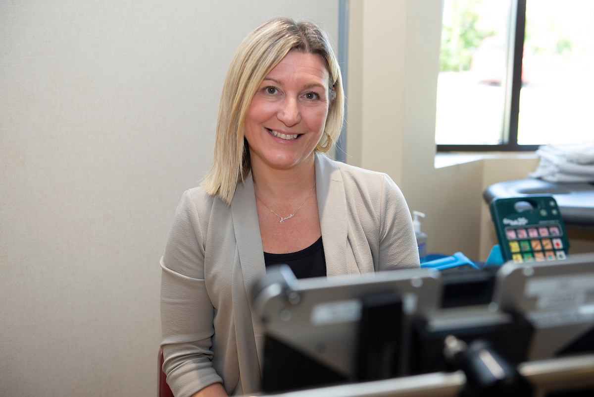 Anick sits in an office. She is smilng.