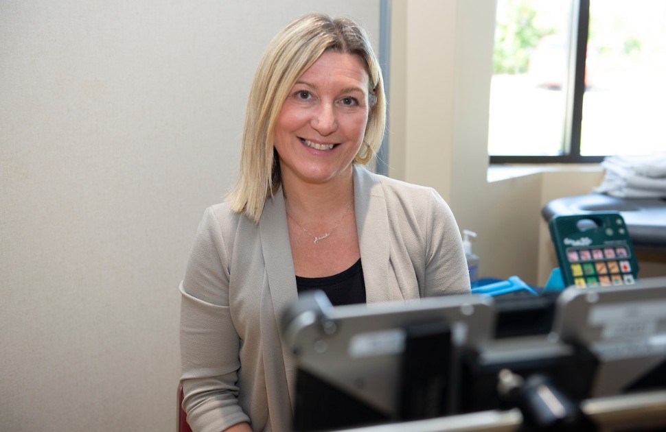 Anick sits in an office. She is smilng.