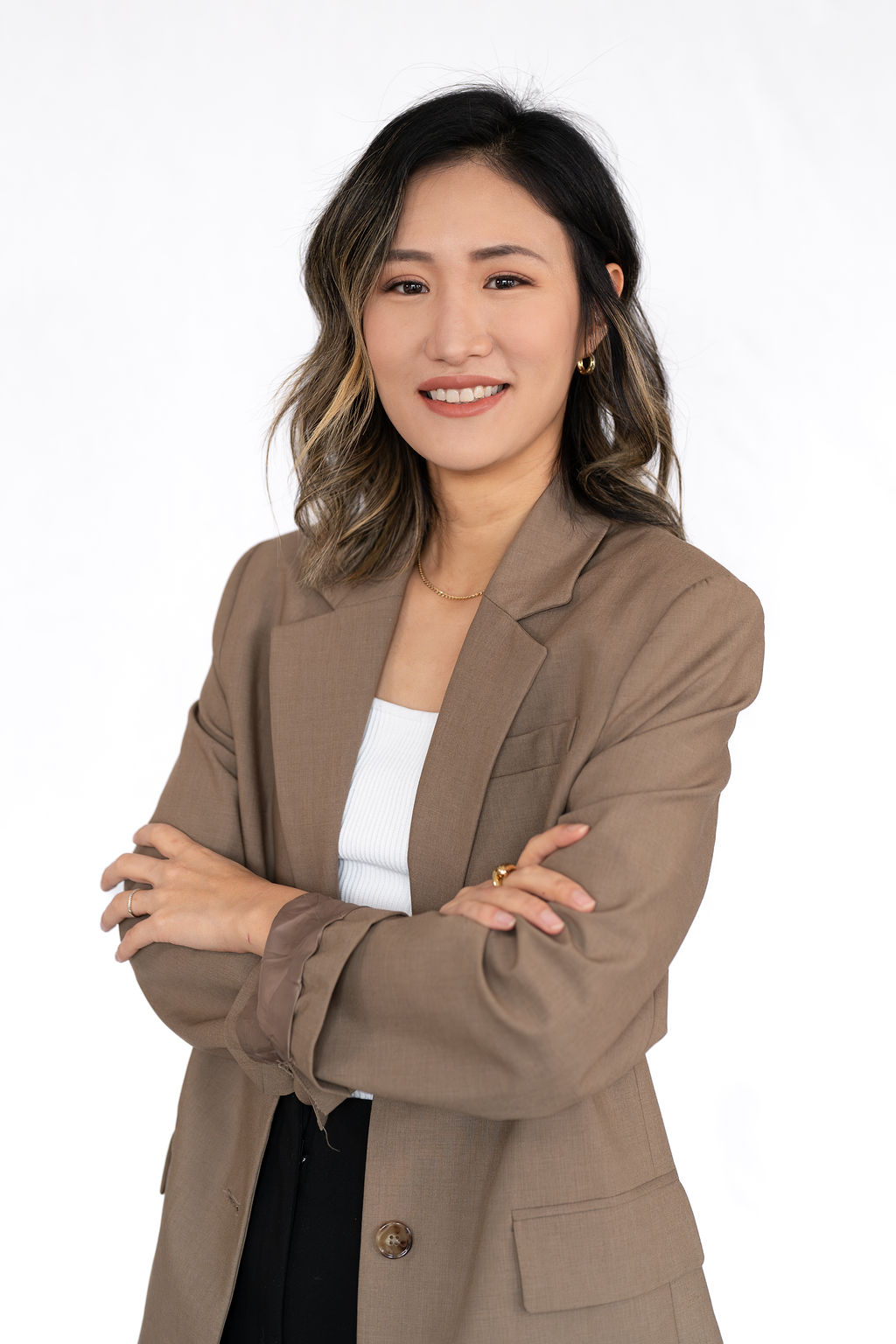 A women with black hair and a brown blazer