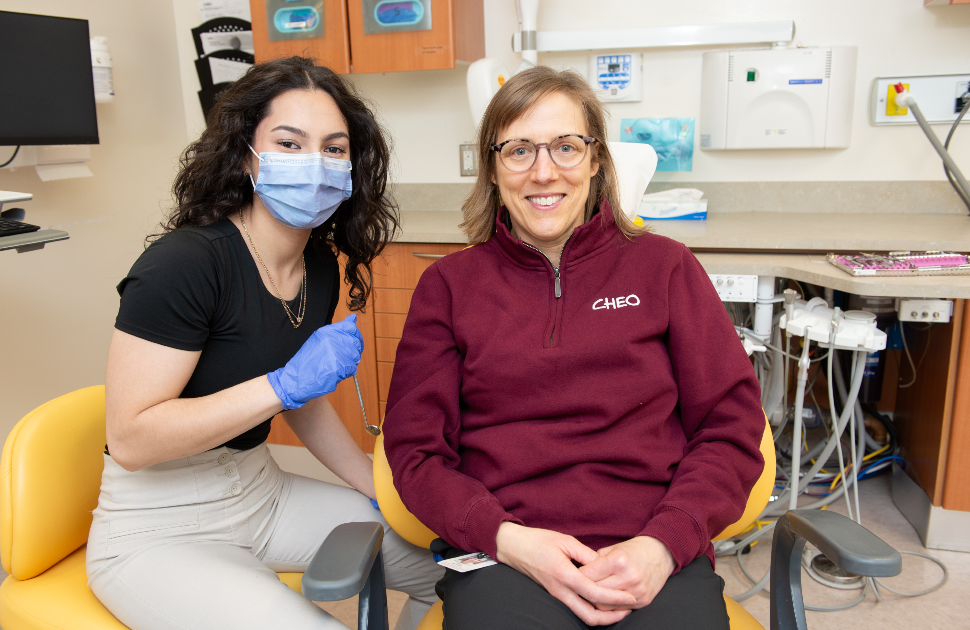 Dental hygieniest smiles with patient in dentist chair