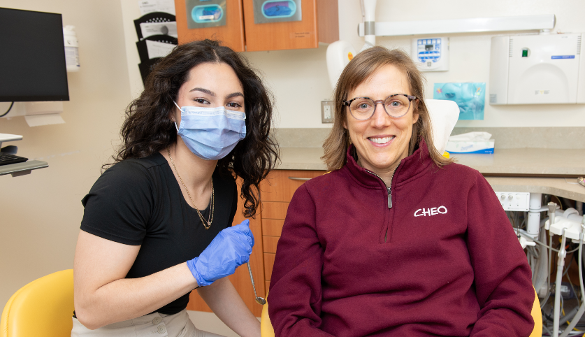 Dental hygieniest smiles with patient in dentist chair