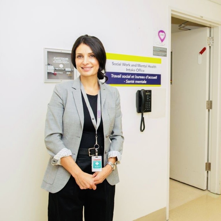 woman stands in front of doorway to social work office