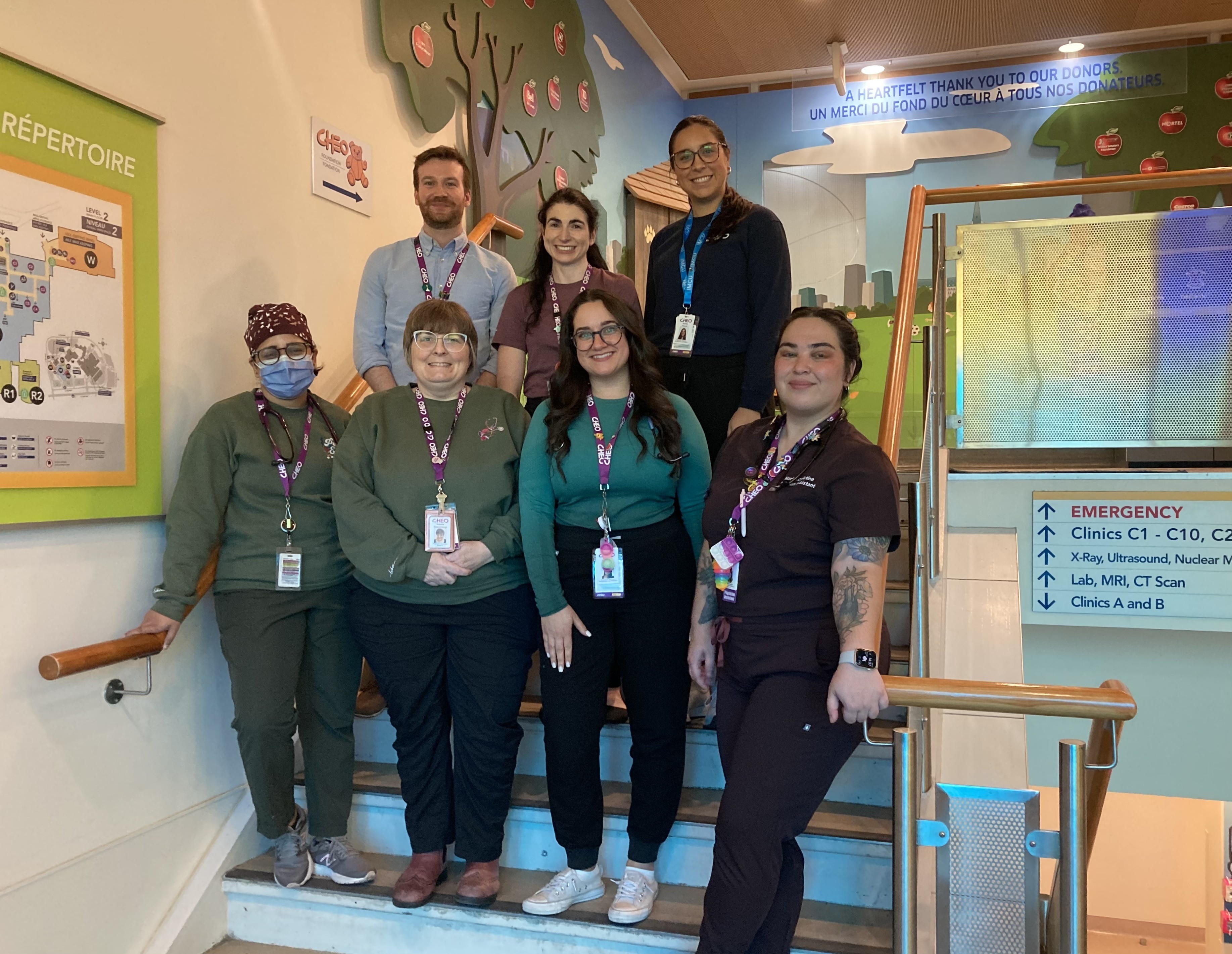 A group of physician assistants stand on a staircase