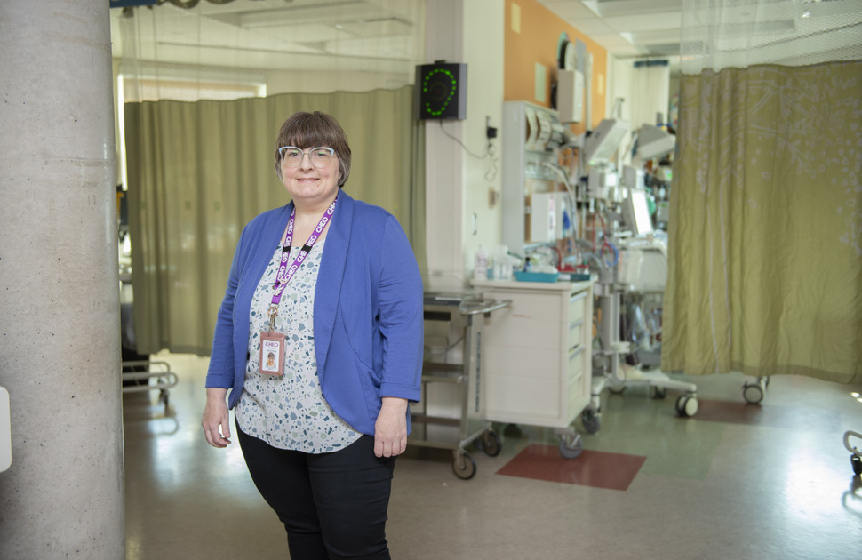 A woman in a blue blazer stands in the NICU