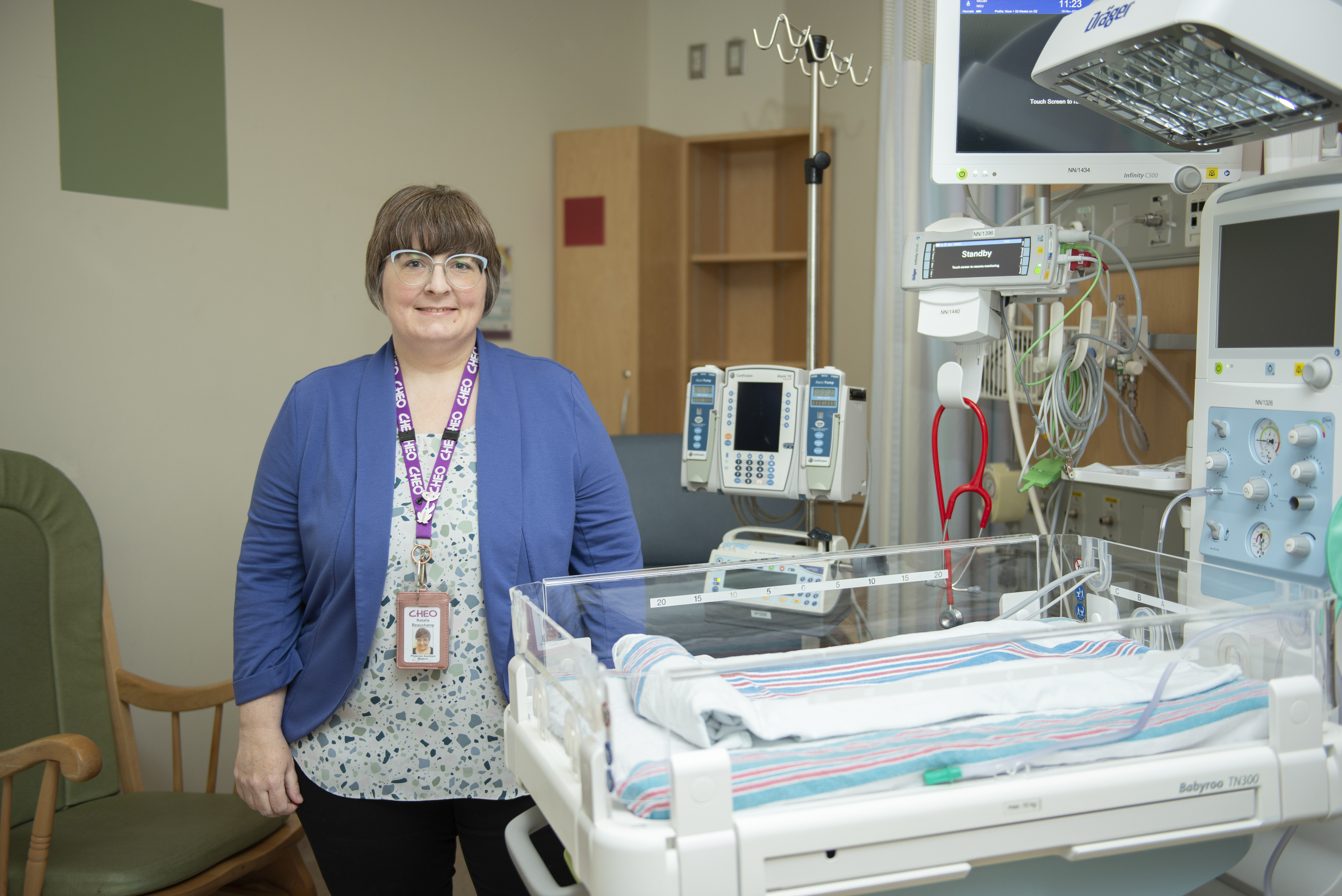 A woman in a blue blazer stands in the NICU