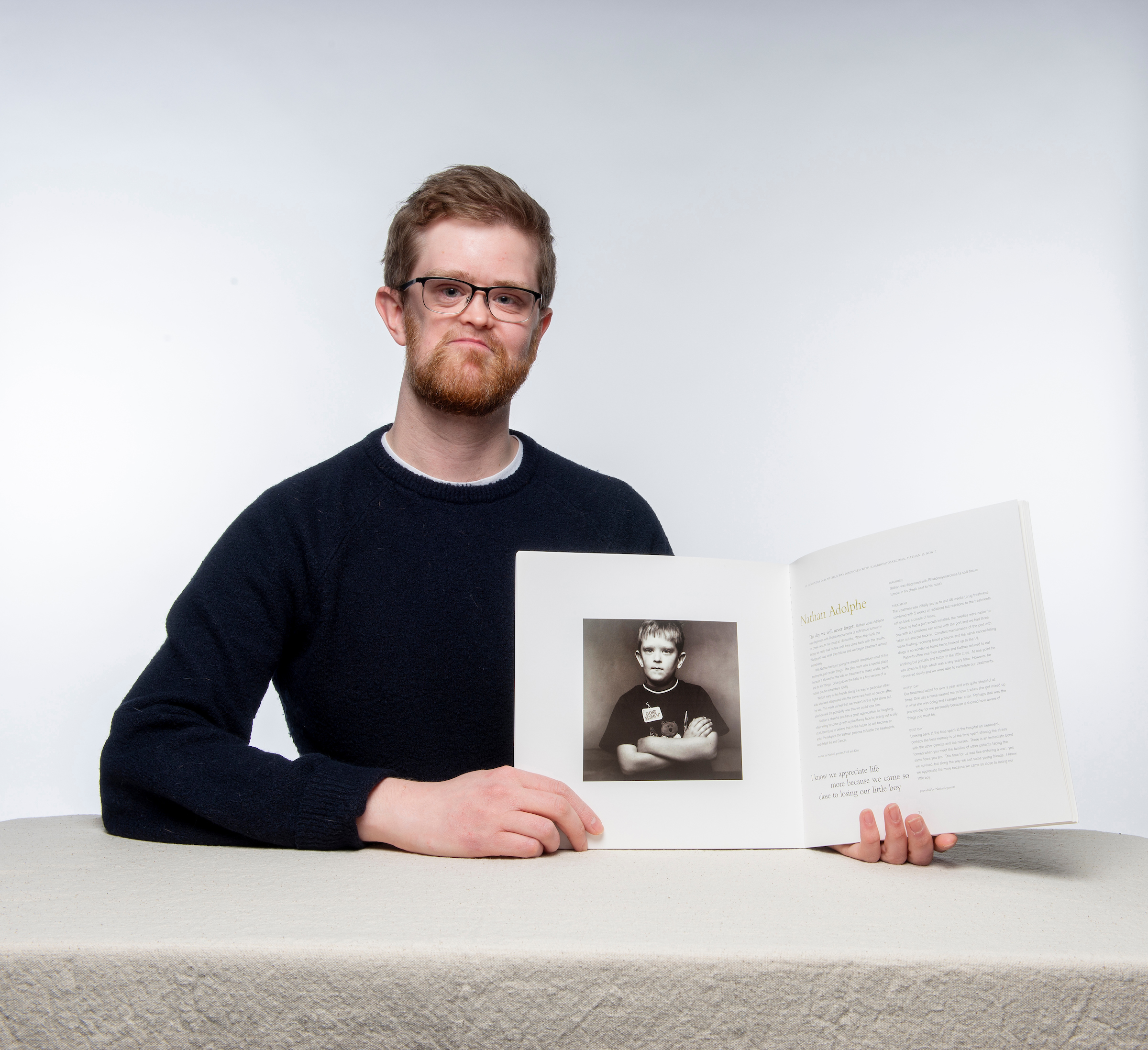 A man with brown hair holding a book