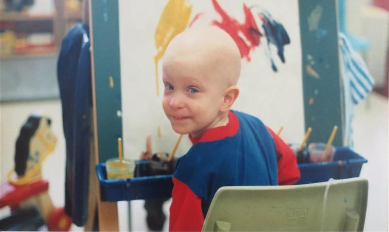 A boy with no hair painting 