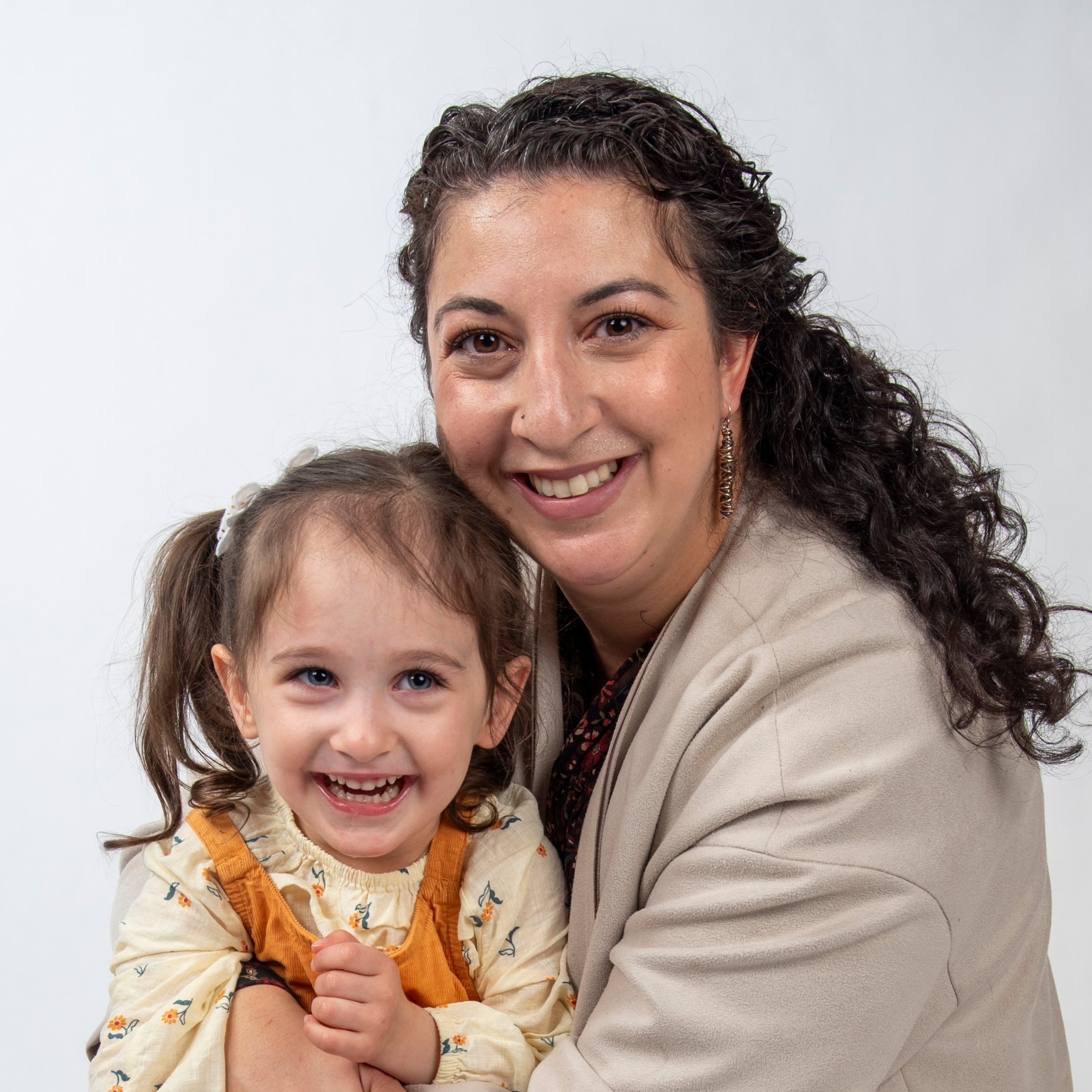 daughter and mom pose together and smile looking at camera