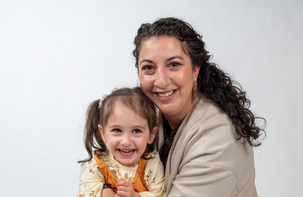 daughter and mom pose together and smile looking at camera