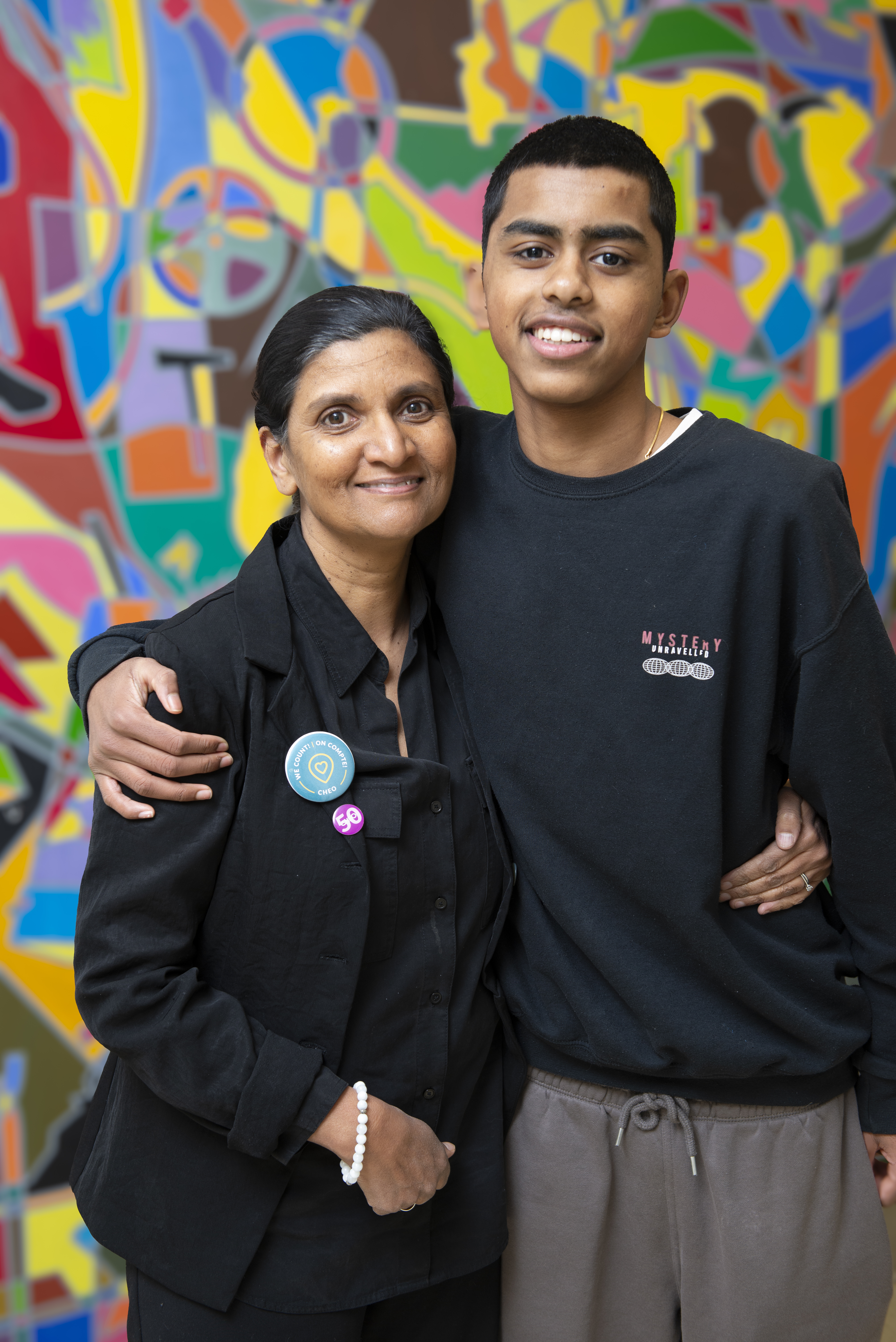 A woman and her son in front of a colourful wall