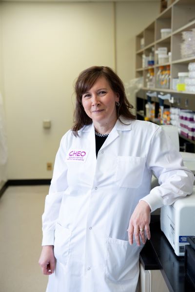 doctor smiles while standing in research lab