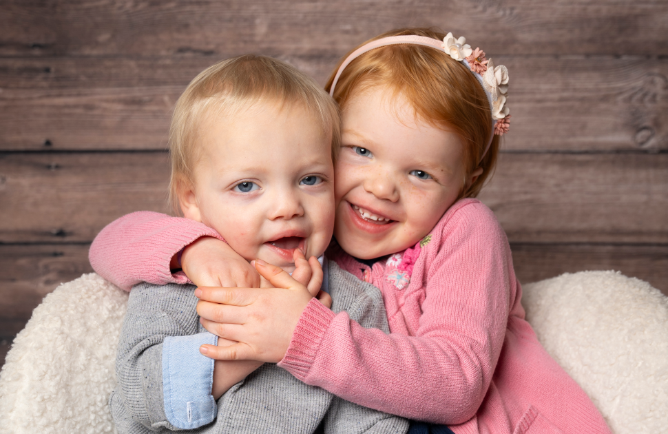 brother and sister hug and pose for camera