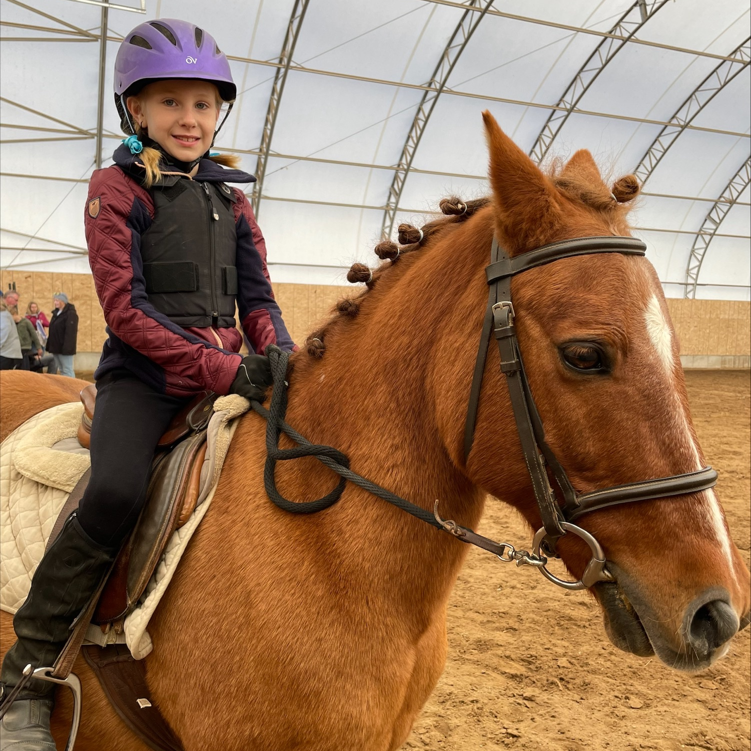 girl smiles while riding a horse