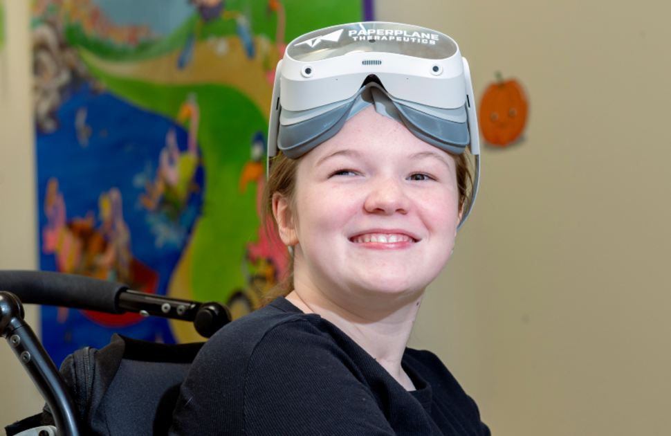 girl smiles while wearing virtual reality headset sitting in wheelchair