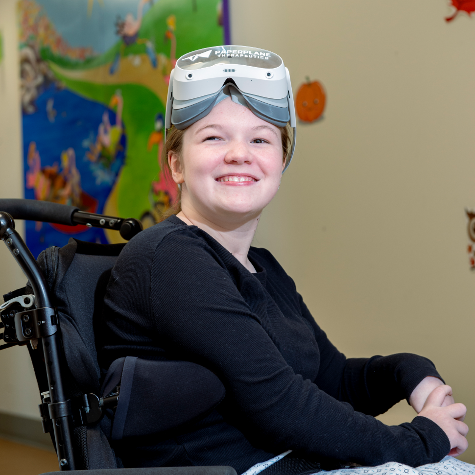 girl smiles while wearing virtual reality headset sitting in wheelchair